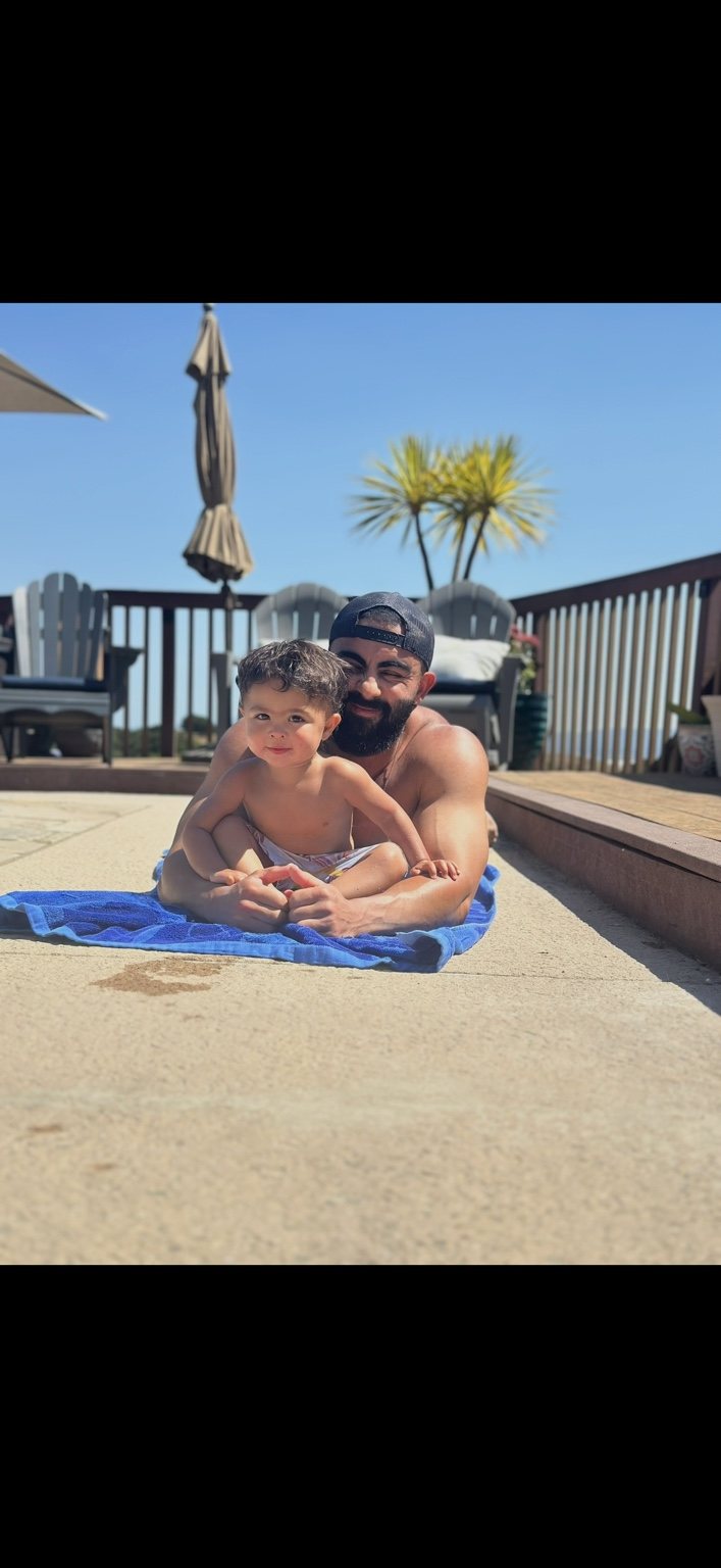 Daniel by the pool with his child